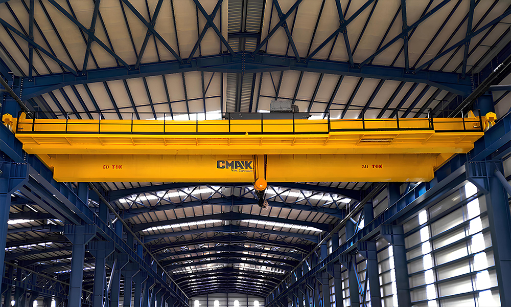 A heavy-duty 50-ton CMAK double-girder bridge crane with a top-running trolley hoist installed in a large steel-structure industrial factory.