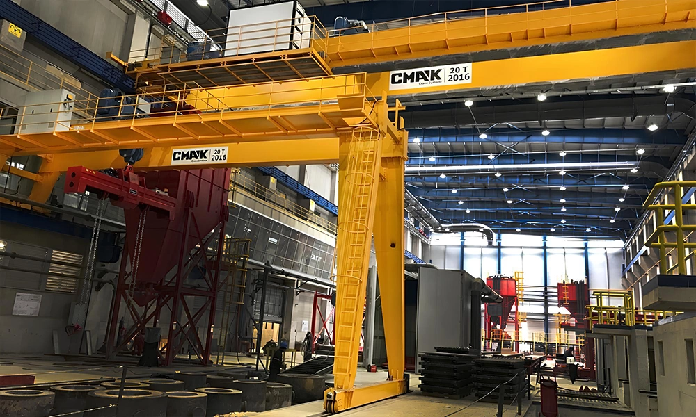 Industrial manufacturing facility utilizing heavy-duty 20-ton yellow gantry cranes CMAK with an integrated service walkway and access ladder for medium-to-heavy material handling.